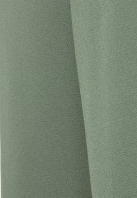 Getextureerde stof in een gedempte groene kleur, met een gladde afwerking, lichte glans en subtiele lichtreflectie, dubbelgevouwen.