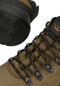 Braune Wanderschuhe mit schwarzen und orangefarbenen Schnürsenkeln, Metallösen, gepolstertem Zungenbereich und strukturierter schwarzer Gummisohle mit Profilmuster.