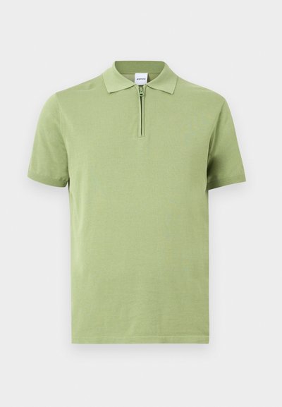 Polo manches courtes vert clair avec col et fermeture éclair à l'avant, présenté à plat sur un fond blanc.