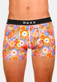 Shorts de boxeur colorés avec un motif floral en rose, orange et bleu. Dotés d'une ceinture noire avec le logo "WAXX" et une couture blanche.