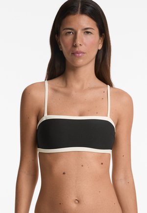 Fekete bandeau bikini felső krém színű díszítéssel és állítható vékony pántokkal. Simaságot biztosító, elasztikus anyagból készült, testhez simuló kialakítással.