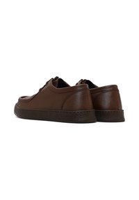 Zapatillas de cuero marrón con acabado texturizado, punta redonda, diseño de cordones y suelas de goma en contraste. Estilo minimalista con detalles de costura sutiles.