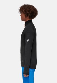 Black striped fleece jacket with a high collar, orange zipper pull. Features a logo patch on the left arm and long sleeves.