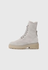 Hellgraue Wildleder-Ankle Boots mit runder Spitze, Schnürung vorne und dicker beiger Sohle. Mit goldfarbenen Ösen und einer Zuglasche an der Ferse.