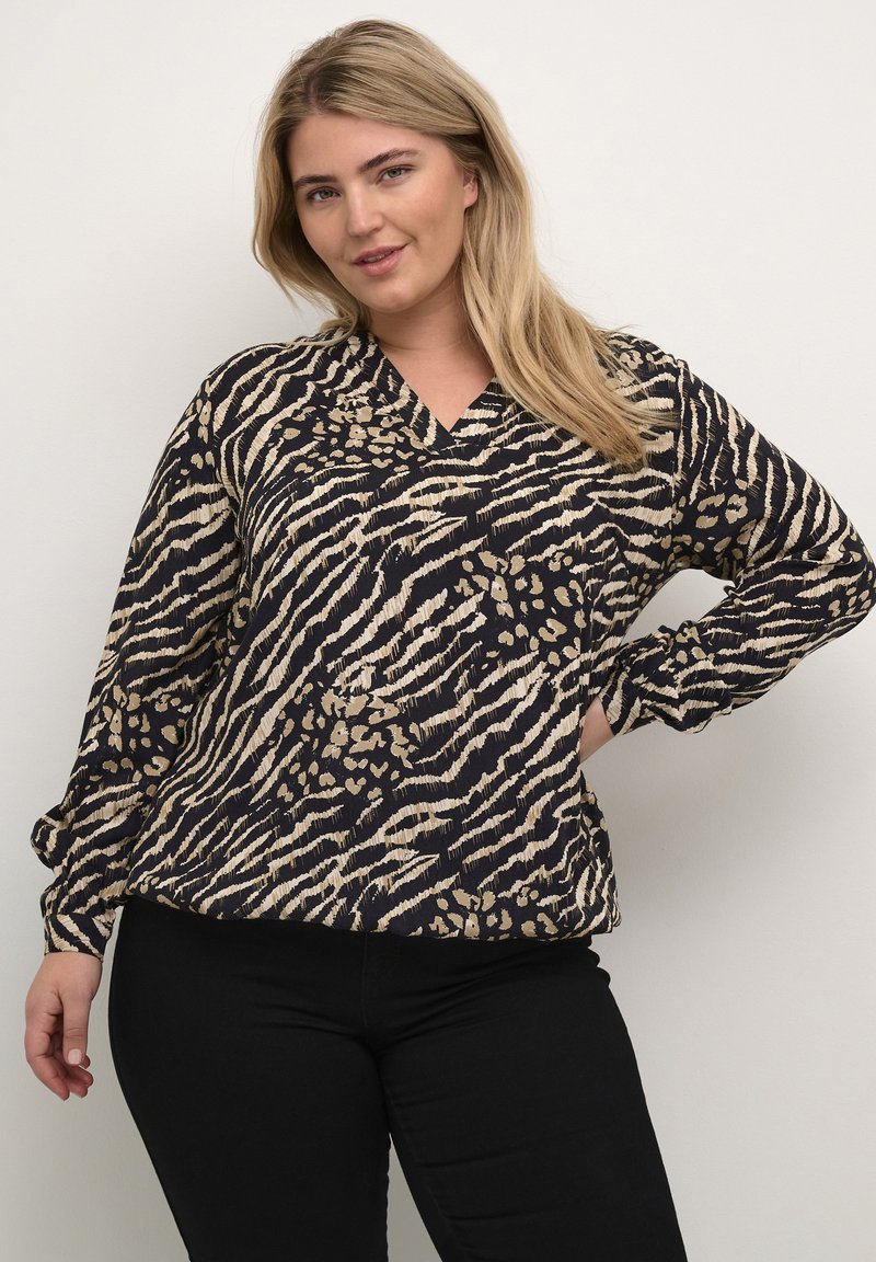 Maglia a maniche lunghe in blu navy con un motivo beige di leopardo e zebra, caratterizzata da scollo a V e vestibilità rilassata. Tessuto morbido e strutturato.