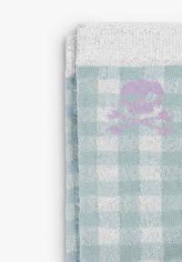 Calcetines a cuadros en azul claro y blanco con un acabado texturizado. Presenta un diseño de calavera y tibias cruzadas en púrpura en un lado.