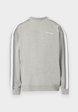 Hellgraues Sweatshirt mit Rundhalsausschnitt, weißen und schwarzen Streifen an den Ärmeln und kleinem weißem Calvin Klein Logo auf der linken Brustseite.
