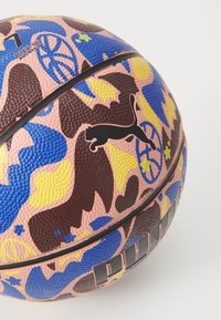 Puma-basketboll med en texturerad yta i rosa fundament, bruna, blå och gula abstrakta mönster samt en svart logotyp.
