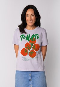 Lichtpaarse katoenen t-shirt met een opvallende grafische afbeelding van rode tomaten en groene tekst. Korte mouwen en een ronde halslijn met een rechte zoom.