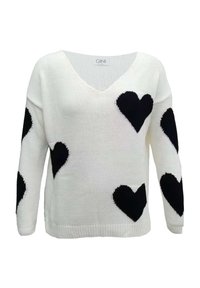 Ein weißer Strickpullover mit V-Ausschnitt, der mit auffälligen schwarzen Herzmustern über den Stoff verteilt ist. Rippbündchen und Saum.