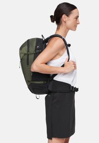 Zaino con una combinazione di colori verde e nero, realizzato in tessuto resistente. Include spallacci regolabili e una cintura per il supporto.