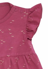 Abito di cotone rosa con maniche corte a volant, scollatura rotonda e motivi di uccelli color crema sparsi su tutta la stoffa. Due chiusure a pressione sulla spalla.
