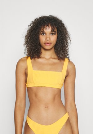Top bikini giallo a coste con scollatura quadrata e spalline larghe, abbinato a un bikini bottom coordinato caratterizzato da un design minimalista a vita bassa.