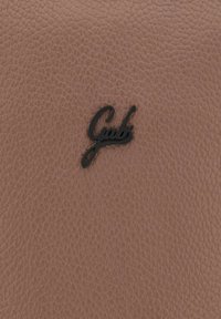 Pelle marrone testurizzata con un sottile motivo a grana che presenta un logo nero corsivo con la scritta "Gabs." Texture liscia e morbida.