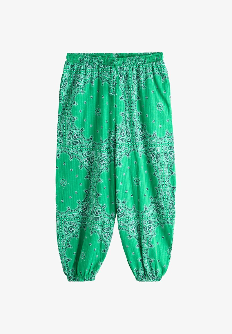 Pantalon ample vert avec taille et poignets élastiques, présentant un motif bandana paisley blanc et noir.