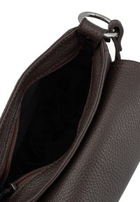 Brown leather bag with a textured surface, zipper closure, and silver hardware. Interior is dark fabric, showing depth and structure.
