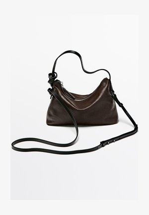 Dunkelbraune Lederhandtasche mit glatter Textur, geschwungener Form und einem Reißverschluss. Verfügt über einen abnehmbaren schwarzen Riemen zum Tragen über der Schulter.