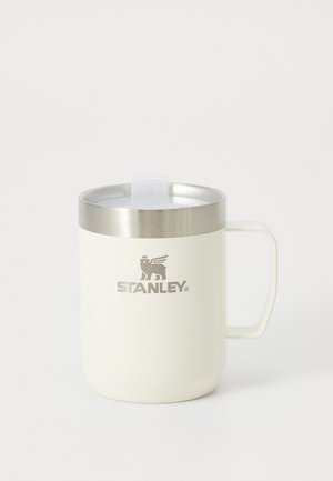 Taza blanca Stanley aislada con asa, borde de acero inoxidable y tapa a prueba de derrames sobre un fondo claro y sencillo.