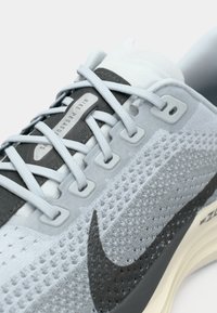 Nike Pegasus αθλητικό παπούτσι σε ανοιχτό μπλε και γκρι. Διαθέτει αναπνεύσιμο επάνω μέρος από δίχτυ, υφή στις λεπτομέρειες και χαρακτηριστικό μαύρο λογότυπο Swoosh.