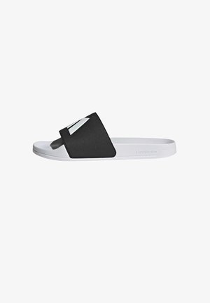 Black slide sandal with a wide strap featuring a silver accent, textured upper, and white sole. Lightweight and casual design.