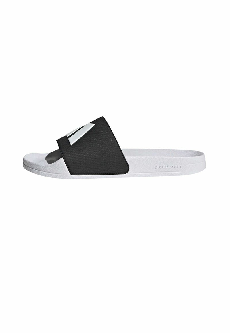 Black slide sandal with a wide strap featuring a silver accent, textured upper, and white sole. Lightweight and casual design.