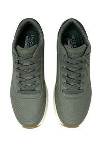 Zapatillas deportivas de color verde oscuro con un upper suave que presenta detalles perforados, diseño de cordones y una suela blanca con un acento de goma.