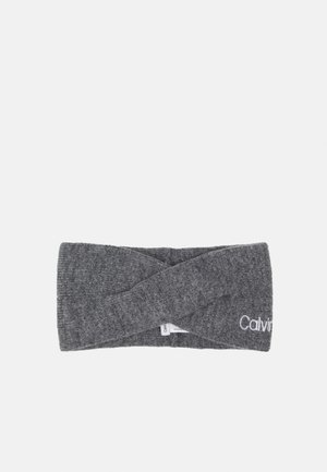Grijze gebreide stoffen hoofdband met gedraaide voorkant en deels zichtbaar Calvin Klein-logo aan één zijde.