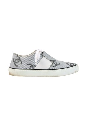 Baskets basses avec semelle blanche, dessus en mesh gris avec motifs abstraits noirs et fermeture à lacets blancs sur fond blanc.
