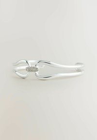 Bracciale in argento caratterizzato da un design fluido con estremità curve e un accento centrale decorato con piccole pietre trasparenti. Texture liscia e lucida.