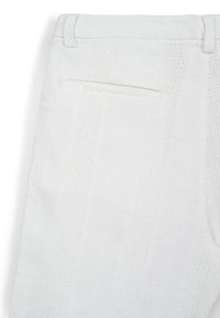 Pantalons en tissu texturé blanc avec un motif à rayures verticales. Dotés d'une taille élastique et d'une poche arrière unique. Le matériau est léger et respirant.