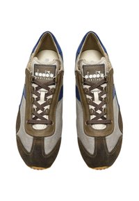 Sneakers con una toma superiore in tessuto grigio e dettagli in suede marrone, caratterizzati da una striscia laterale blu, lacci marroni e logo sulla linguetta.