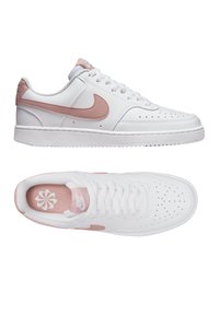 Sneakers bianchi in pelle con il logo Nike rosa chiaro, zona della punta perforata e dettagli rosa sulla linguetta e sulla soletta. Lacci bianchi piatti.