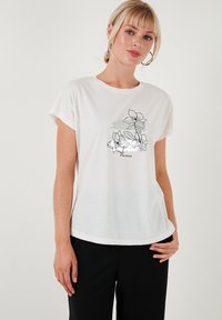 Hvid, kortærmet t-shirt lavet af blødt stof med et sort blomsterdesign og ordet "Floraison" trykt under det.