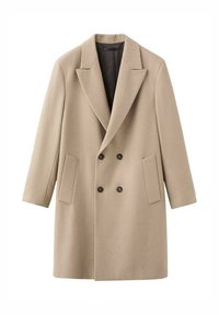 Abrigo beige de doble botonadura con grandes solapas, dos bolsillos delanteros y forro negro. Confeccionado en una tela texturizada, de apariencia suave.