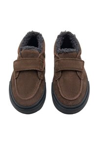 Zapatos de ante marrón con una correa de velcro, forro gris de felpa y suela de goma negra. Punta redondeada con textura suave y diseño simple.