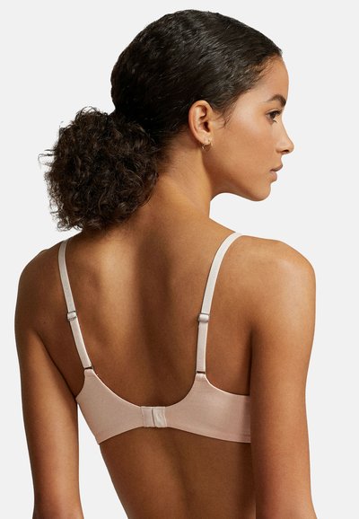 Rosa ribbad bh med smala justerbara band och en hyska-och-ögla stängning bak. Slät textur med minimalistiska design detaljer.