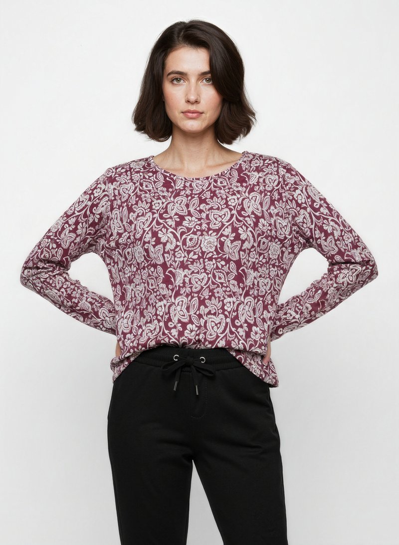 Maglietta a maniche lunghe color marsala con motivo floreale bianco, scollatura rotonda, vestibilità rilassata, abbinata a pantaloni neri con coulisse.