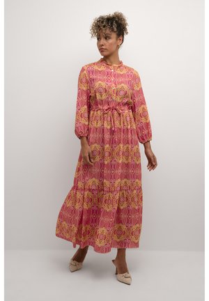 Maxi dress in pink and gold patterned fabric, featuring long sleeves, a cinched waist, and a flowing skirt with tiered detailing.