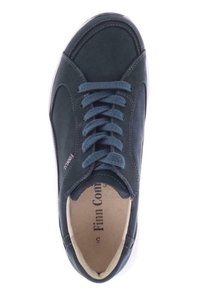 Baskets en suede bleu foncé avec un bout arrondi, des lacets plats et une semelle en caoutchouc blanche. La doublure intérieure est beige avec l'étiquette de la marque visible.