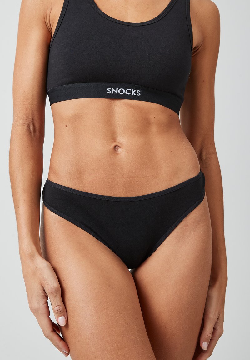 Soutien-gorge en coton noir et culotte de bikini assortie avec une texture lisse. La bande est imprimée en blanc avec "SNOCKS". Design minimaliste avec une coupe classique.