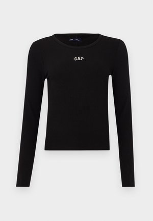 Svart ribbestrikket langermet topp med rund hals og brodert "GAP"-logo i hvitt på brystet. Glatt tekstur, tettsittende design.