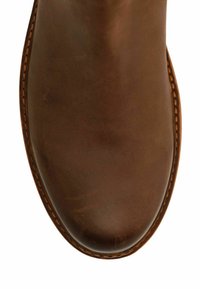 Bruine leren laars met een ronde neus en zichtbare stiksels. Gladde textuur met een gepolijste afwerking. Geen opmerkelijke patronen of hardware.