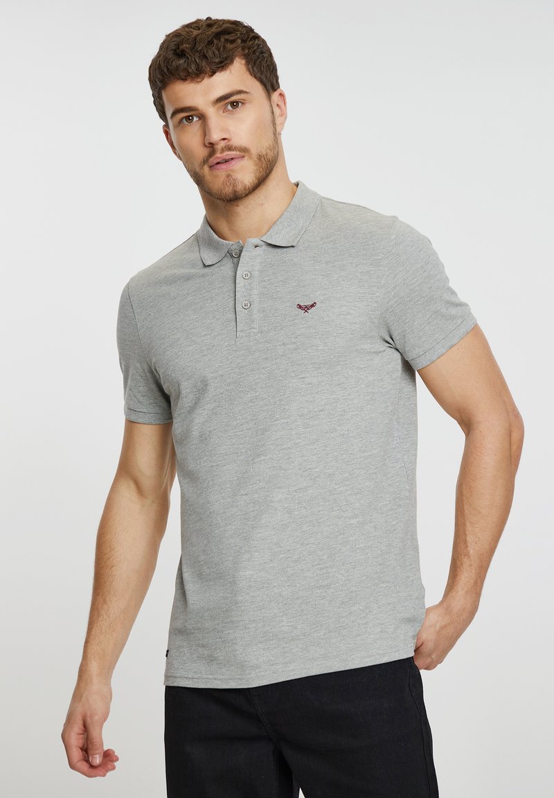 Polo gris con una textura suave, que presenta una tapeta de tres botones y un pequeño logo bordado en el pecho. Diseño de mangas cortas.