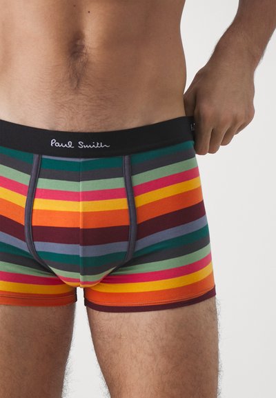 Boxer-briefs rayés avec une ceinture noire arborant le logo "Paul Smith". Les couleurs incluent vert, rouge, orange, violet et gris. Matière en coton.