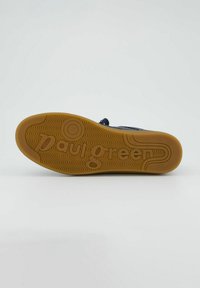Suola di una scarpa con texture in gomma, colore beige, e motivo a onde con "paul green" impresso al centro.