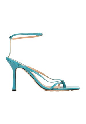 Sandale à talon haut turquoise avec fines brides, boucle à la cheville et talon aiguille étroit.
