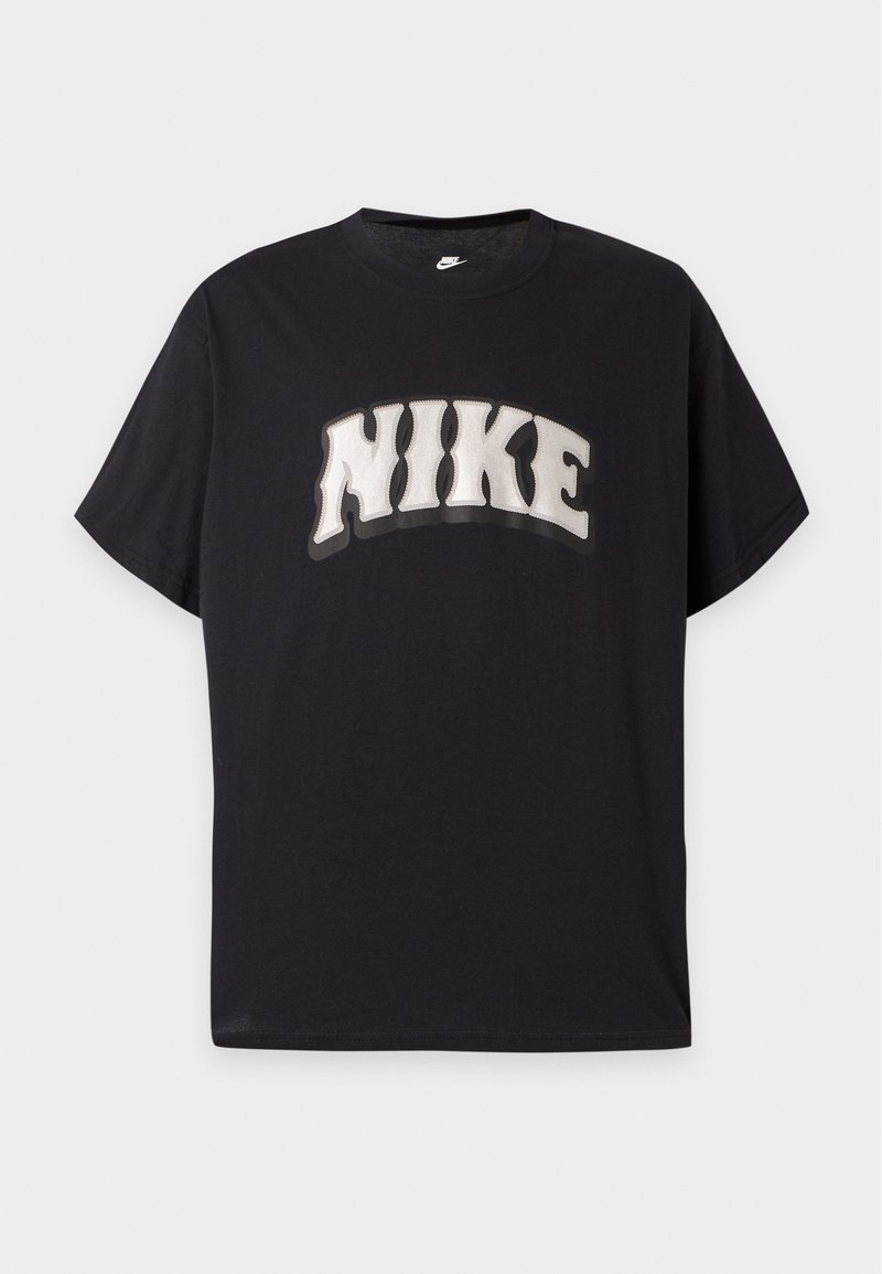 T-shirt nera a maniche corte con grande scritta bianca "NIKE" in grassetto e stile ondulato sul petto e un piccolo logo Nike bianco all'interno del colletto.