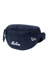 Riñonera de corduroy azul marino con forma redondeada, cierre de cremallera y correa ajustable. Presenta un bordado blanco de "New Era" y detalle del logo.