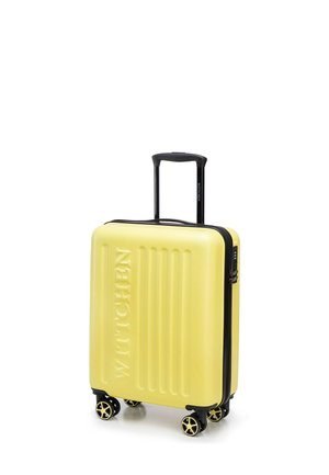 Yellow hard-shell suitcase with black zipper, four spinner wheels, and an extended black telescopic handle.