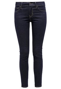 Jean skinny bleu foncé en denim, avec un design classique à cinq poches, des coutures jaunes et une fermeture à bouton à la taille.